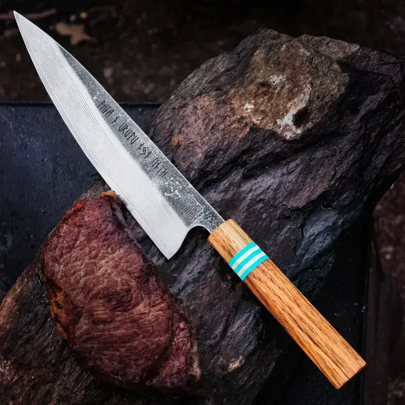 Forhandlerens produktfoto af Riceknife VALKYRIE III gyuto-kokkekniv med mønstret damaskusklinge og håndtag i rødeg, blå G10 og messing